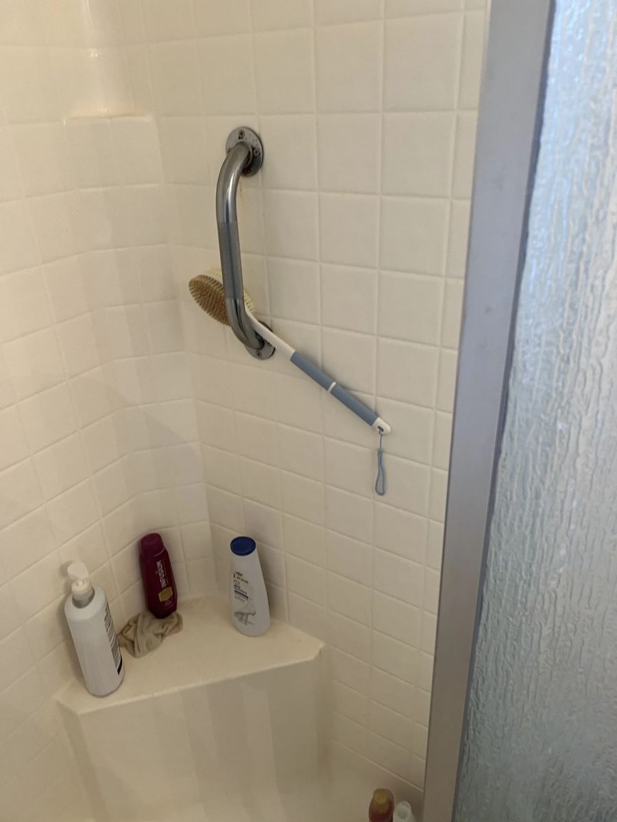 Finished shower interior with polished fixtures and safety grab bars