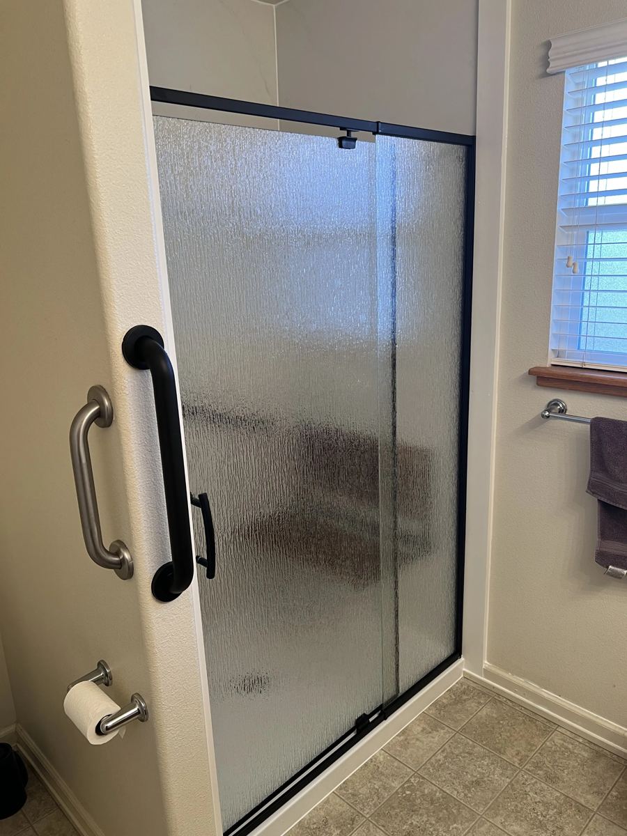 Completed bathroom shower with a full glass door enclosure